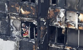 Một lính cứu hỏa khám xét hiện trường tòa chung cư Grenfell. Ảnh: SWNS