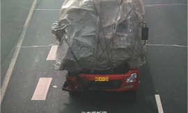 Thay vì đi thay kính, tài xế xe tải đã dùng bạt bịt kín đầu xe, khoét một lỗ nhỏ để nhìn đường.