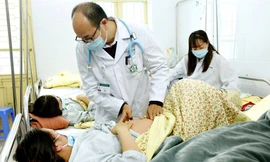 PGS. TS Đỗ Duy Cường đang thăm khám cho BN sởi điều trị tại Khoa Truyền nhiễm. Ảnh: D.Ngọc - TTX