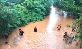 Lực lượng cứu hộ sử dụng lưới để tìm kiếm cháu bé bị nước cuốn