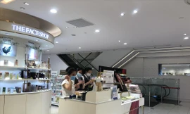 Nhân viên cửa hàng mỹ phẩm đeo khẩu trang tiếp khách