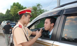 Cảnh sát giao thông kiểm tra nồng độ cồn của một lái xe Ảnh: Hồng Vĩnh 