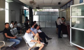 Người dân ngồi chờ làm thủ tục đổi bằng lái xe tại Tổng cục Ðường bộ. Ảnh: Ðức Anh 