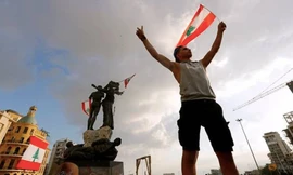 Một người biểu tình giương cờ Li-băng trên Quảng trường Liệt sĩ ngày 9/8 