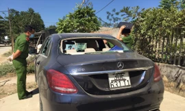 Chiếc xe sang để bên đường, kính sau và các cửa kính đều bị đập vỡ, trong xe có dấu vết máu