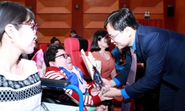 Bí thư thứ nhất T.Ư Ðoàn Nguyễn Anh Tuấn trao phần thưởng cho tấm gương thanh niên khuyết tật, tối 28/12 Ảnh: Dương Triều
