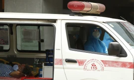 Nhân viên y tế đưa người nước ngoài vào khu xét nghiệm COVID-19 tại Bệnh viện Việt Pháp- Hà Nội sáng 26/3 Ảnh: Như Ý