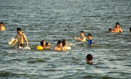 Người lớn, trẻ nhỏ vác can nhựa, săm xe ra Hồ Tây tắm mát