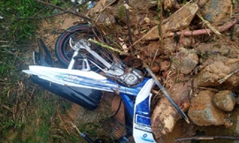 Chiếc xe máy của 2 thanh niên người Quảng Nam bị đất đá vùi lấp. Ảnh: CTV