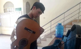 Một thành viên ban nhạc đường phố kiểm tra nhạc cụ sau khi được quy tắc đô thị phường trả lại. Ảnh Nguyễn Thành