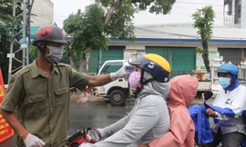 Cán bộ phường làm nhiệm vụ giám sát người ra vào ở một khu dân cư trên địa bàn Đà Nẵng. Ảnh: Nguyễn Thành
