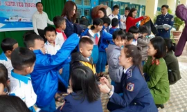 Các nữ chiến sĩ Vùng cảnh sát biển 2 trao áo ấm và quà cho học sinh có hoàn cảnh khó khăn, là con em của đồng bào dân tộc Cor. 