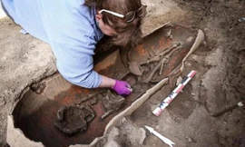 Một nhà khảo cổ học đang làm việc bên bình gốm chứa hài cốt người chết được tìm thấy trên đảo Corsica của Pháp.