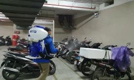 Công nhân phun thuốc khử khuẩn tại khu vực để xe