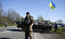 Một lính Ukraine đứng trước xe tăng ở trạm kiểm soát tại làng Malinivka, Slaviansk, đông Ukraine 