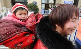 Em bé trên lưng mẹ về quê ăn Tết