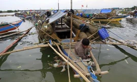 Một dân chài cố định thuyền của mình ở nơi an toàn để tránh bão Rammasun