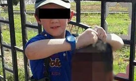 Cậu bé tươi cười nắm thủ cấp của một binh sỹ Syria