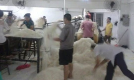 Công nhân dẫm đạp lên mỳ trong nhà máy Tongcheng.