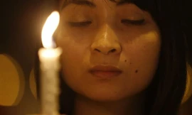 Một cô gái cầm nến cầu nguyện cho chiếc máy bay mất tích