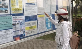 Công nhân đọc nhu cầu tuyển dụng lao động tại khu chế xuất Tân Thuận (quận 7) ảnh: U.P