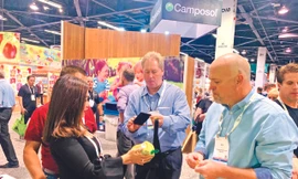 Chị Ngô Tường Vy (bên trái) giới thiệu trái cây Việt Nam tại Hội chợ PMA tại Mỹ ẢNH: NVCC