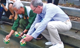 Hai cựu chiến binh Lê Bá Dương và Mike thả hoa đăng trên sông Thạch Hãn