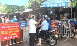 Đo nhiệt độ người dân trước khi họ vào chợ tại Hải DươngNguồn: QĐND