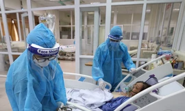 Bác sĩ Bệnh viện Nhiệt đới T.Ư cơ sở 2 chữa bệnh cho bệnh nhân mắc Covid-19 Ảnh: Mạnh Thắng