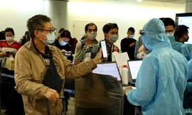 Nhân viên kiểm dịch kiểm tra khai báo y tế, hộ chiếu người nhập cảnh tại sân bay Tân Sơn Nhất - ảnh: Ngô Bình, mạnh thắng