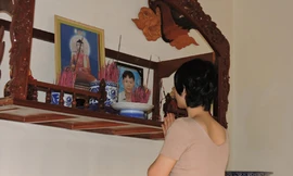 Bà Tâm thắp nén nhang cho người chồng quá cố