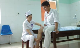 Đại úy Kim Oanh chăm sóc bệnh nhân điều trị tại Bệnh viện Quân y 211 ẢNH: NVCC