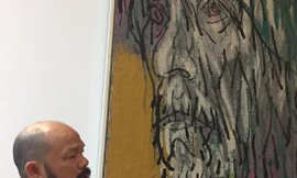 Họa sĩ Nguyễn Linh bên bức chân dung Bùi Xuân Phái của mình