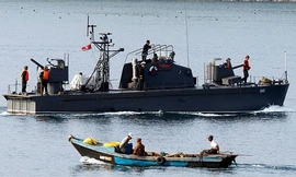 Một thuyền đánh cá Triều Tiên đi ngang tàu tuần tra của hải quân nước này. Ảnh: AP 