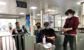 Hành khách được rửa tay sát khuẩn và phát khẩu trang miễn phí khi qua cửa soát vé tại bến Giáp Bát. Ảnh: T.Đảng