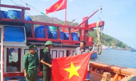 Trạm KSBP Đại Lãnh (Đồn Biên phòng Đầm Môn) tặng cờ Tổ quốc cho ngư dân. ẢNH: NGUYỄN MINH