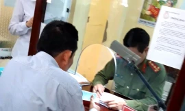Cán bộ phòng QLXNC Hải Dương "báo giá" người dân làm hộ chiếu nhanh.ảnh: DH