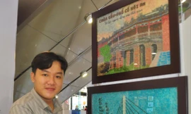 Anh Khưu Tấn Bửu, chủ cơ sở tranh gạo Tấn Bửu bên sản phẩm của mình.   ẢNH: HÒA HỘI 