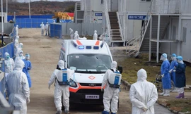 Nhân viên y tế khử trùng xe cứu thương chở bệnh nhân ở bệnh viện dã chiến Hỏa Thần Sơn ở Vũ Hán. Ảnh: Xinhua