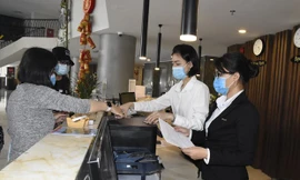 Đo thân nhiệt du khách tại khách sạn. Ảnh: TTXVN