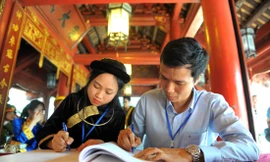 Tiến sĩ Vòng Bính Long ghi sổ vàng tại Văn Miếu - Quốc Tử Giám chiều 11/11. Ảnh: Xuân Tùng