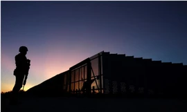 Một binh sỹ thuộc lực lượng Vệ binh quốc gia Mỹ đứng gác ở khu vực biên giới Mỹ-Mexico, phía trước là hàng rào chắn bằng thép. Ảnh: Reuters 