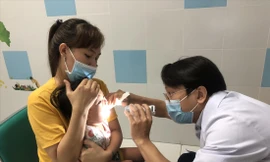 BS Nguyễn Đình Qui khám bệnh cho bệnh nhi sáng 19/3. Ảnh: U.P