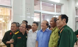 Nhà thơ Hữu Thỉnh (thứ 3 từ phải sang) bên những cựu binh xe tăng tại lễ ra mắt cuốn sách “Theo vết xích xe tăng” tập 3. Ảnh: KIẾN NGHĨA