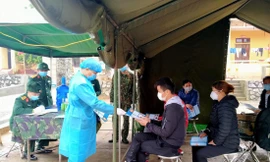 Các “chiến sỹ áo trắng” thăm khám, tiếp nhận người cách ly từ Trung Quốc trở về. Ảnh: Duy Chiến