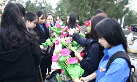 Các bạn đoàn viên, thanh niên nâng niu những đóa hoa trước khi dâng lên mộ liệt sĩ. Ảnh: THANH LỘC