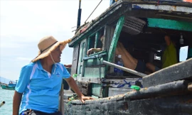 Lão ngư Nguyễn Quang tranh thủ vừa thả lưới, vừa tuyên truyền cho các ngư dân trên các tàu đánh bắt gần bờ. Ảnh: Giang Thanh 