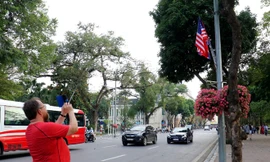 Du khách nước ngoài đứng trên đường Đinh Tiên Hoàng chụp ảnh quốc kỳ Việt Nam-Mỹ-Triều Tiên chiều ngày 21/2. ảnh: Như Ý