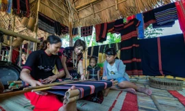 Trần Thị Một (thứ 2 từ trái sang) hướng dẫn các bạn trẻ cách dệt thổ cẩm truyền thống của người Cơ Tu. Ảnh: NVCC