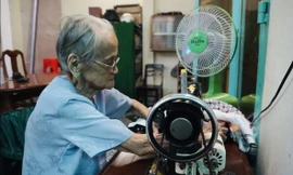 Mẹ Quýt bên chiếc máy may cũ kĩ, theo bà suốt mấy chục năm qua 